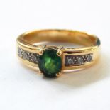 18ct gold, diamond and green stone dress ring set central oval stone flanked by small diamonds to
