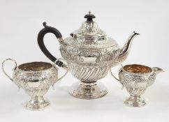 Victorian silver three-piece tea service, the top with engraved and embossed foliate decoration