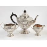 Victorian silver three-piece tea service, the top with engraved and embossed foliate decoration