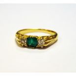 Gold coloured metal emerald and diamond ring, square cut emerald (with chip to corner) flanked by