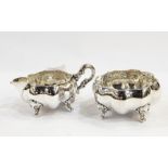 German silver-coloured metal sugar bowl and matching cream jug, each raised on four scroll tab