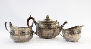 Victorian silver three-piece tea service of oval ribbed form with engraving scrolling decoration,