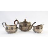 Victorian silver three-piece tea service of oval ribbed form with engraving scrolling decoration,