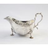 Georgian style silver gravy boat with reeded border, scroll handle, raised on short cabriole legs