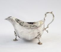 Georgian style silver gravy boat with reeded border, scroll handle, raised on short cabriole legs