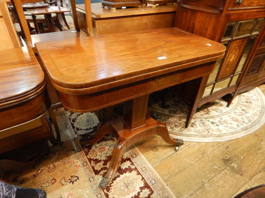 Regency brass inlaid rosewood foldover swivel top card table, having curved corners, brass line