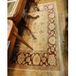 Persian style wool carpet, the cream ground with floral sprays and symbols, in pink, cream and wine,