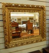 Ornate gilt wall mirror, pierced foliate border, approx 74 x 80 cm