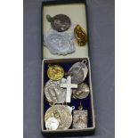 A collection of white metal medallions,