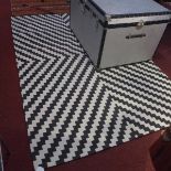 A contemporary black and white woollen carpet with zig zag design,