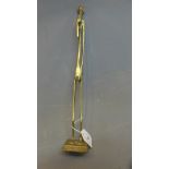 A Giacometti style elongated brass sculpture of a gentleman,