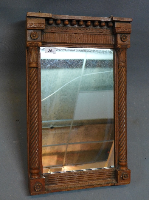 An early 20th Century oak pier mirror, the breakfront pediment above barley twist pilasters,