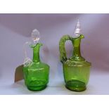 A pair of green glass decanters.