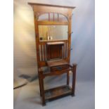 A Liberty's style Arts and Crafts oak hall stand having bevelled mirror back plate,