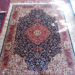A Keshan style carpet with central floral medallion on a blue ground contained by many borders.