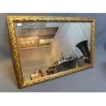 A contemporary giltwood wall mirror, the frame decorated with flowers,