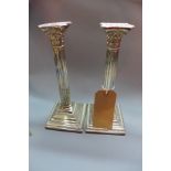 A pair of silver plated corinthian column candlesticks