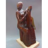 An early 20th Century carved pitch pine statue of a lady playing a harp, raised on marble base.