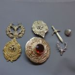 A collection of cast metal Scottish kilt pins and badges