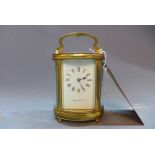 A 20th Century Mappin and Webb brass carriage clock of oval form having bevelled glass panels,