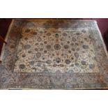 A large fine persian Kashan carpet with central repeating floral motifs on a cream ground