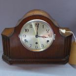 An oak cased Westminster chiming mantle clock, the silvered dial with Arabic numerals and chime/
