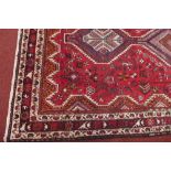 A fine North West Persian Afshar rug with triple pole medallion on a rouge field with multi