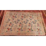 An early 20th century French Aubusson carpet with floral design on a beige ground contained by