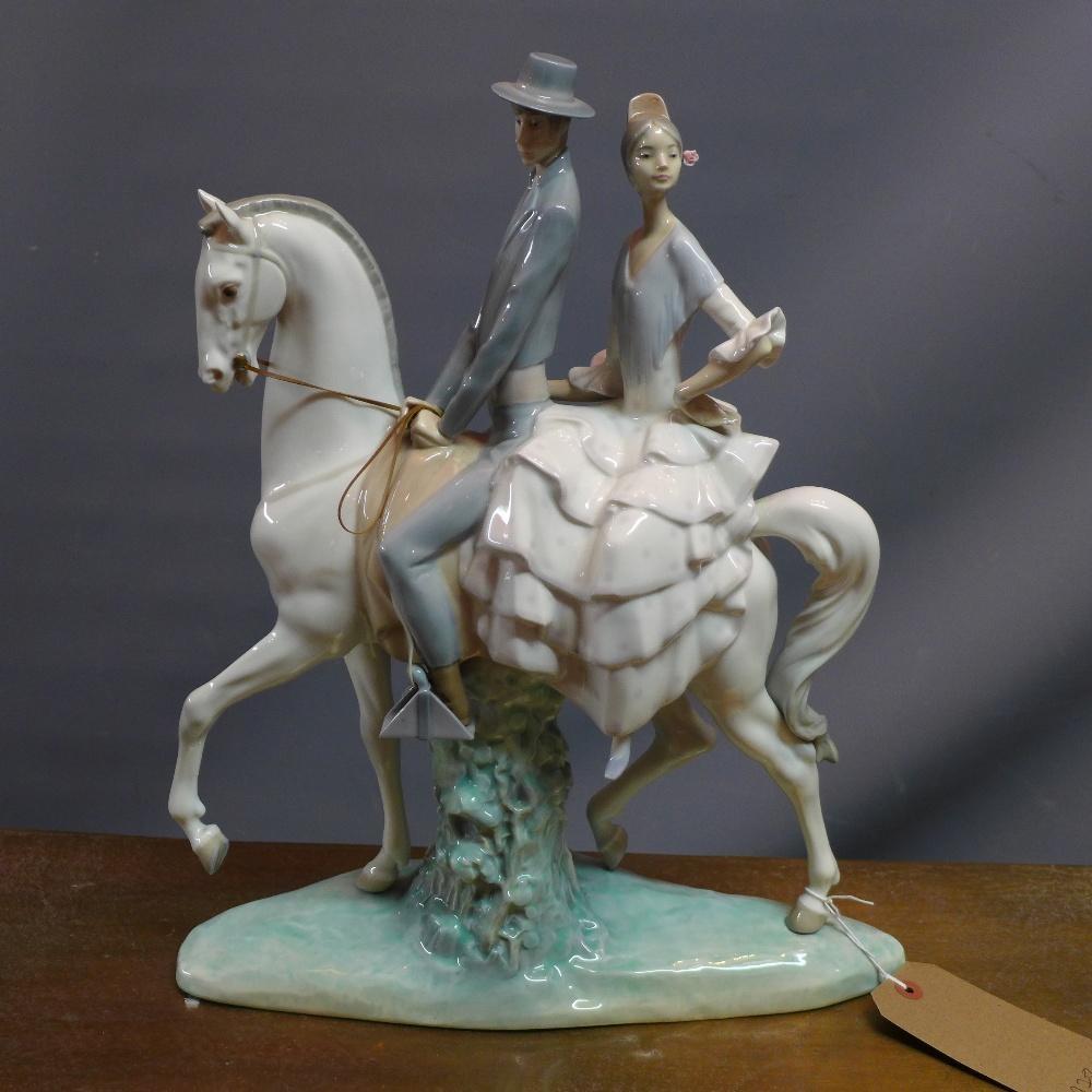 A Lladro figure of a couple on a horseback H.45cm