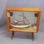 A scratch built model of a fishing boat, in display case raised on splayed legs, H. 44cm (boat)