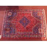 A fine North West Persian Qashqai rug with central diamond medallion on a red field contained by