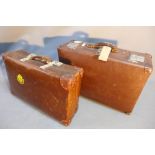 Two vintage brown leather suitcases.