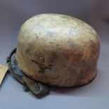 A German Third Reich helmet, bears insignia and label