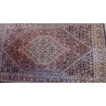 A Persian Bidjar rug with central floral diamond medallion contained by repeating floral and