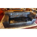 A 20th century black leather two seater sofa raised on chrome feet.