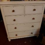 An early 20th century white painted pine chest of two short over three long drawers raised on bun