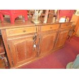 An Early 20th century French oak sideboard with three drawers over three doors raised on plinth