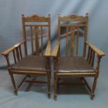 A pair of arts and crafts oak armchairs having black leather seats raised on tapered legs joined
