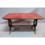 An early 20th century mahogany coffee table with red leather top raised on lyre supports and brass