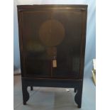 A 20th century Chinese black lacquered wedding cabinet with two doors enclosing single drawer and