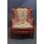 A Louis XV style walnut armchair with pink velour upholstery raised on cabriole legs