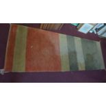 A contemporary runner with green, yellow and orange striped design. 240x83cm