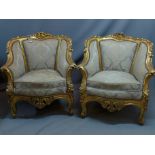 A pair of early 20th century giltwood fauteuil in the Rococo taste with floral damask upholstery