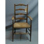 An early 20th century oak ladder back armchair with rush seat.