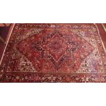 A fine North West Persian Heriz carpet, the floral lozenge on a rouge field within ivory