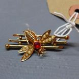 A yellow metal brooch mounted with a bee having central red stone, bearing indistinct hallmark,