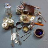 A collection of silver, to include salts, peppers, sugar tongs, stamp purse, heart charm, mustard