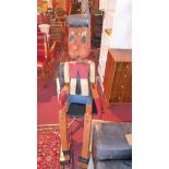 An over-sized painted wooden model of Pinocchio, having articulated limbs, H. 210cm