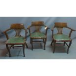 A set of three early 20th century oak desk chairs.