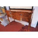 A Georgian style yew wood serpentine fronted side table with four drawers raised on tapered legs and